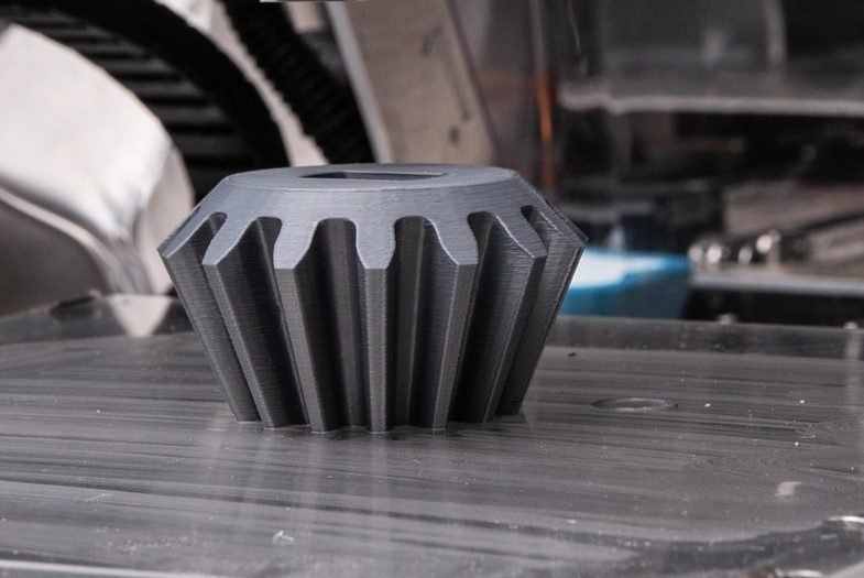 Engranaje cónico fabricándose en una impresora 3D de cámara cerrada